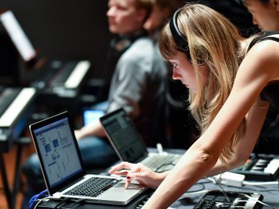 A woman wearing headphones performing live using Ableton
